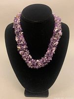 Photo of the amethyst nugget bead necklace displayed on a black bust, showing the full necklace and the color and texture of the amethyst beads.