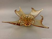 View of amber freeform blown glass bowl showing organic, multi-pointed design and translucent amber coloring.
