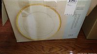 Original box of the Martha Stewart Everyday porcelain dinnerware 20-piece set showing design of plate with gold decorative rim.