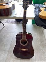 Full front view of the dark brown acoustic guitar showing the headstock with the Talent logo and entire neck and body.