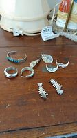 Overview of the jewelry pieces displayed on a wooden surface including earrings and bracelet with missing backs noted. Stamped Mexican 925 silver pieces.