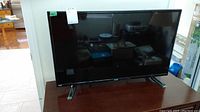 Front view of RCA 32-inch LED TV on stand with screen off.