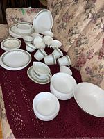 Wide arrangement of dishes on red blanket and floral couch