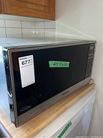 Front view of Panasonic microwave oven with black reflective door and control panel on right side. Size approx 22x18x12 inches.