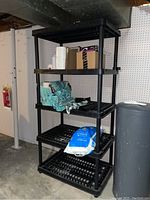 Full view of black resin shelving unit with 5 shelves. Items on shelves not included.