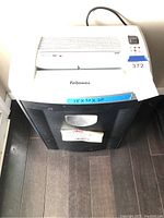 Front view of Fellowes paper shredder showing control panel, feed slot, and trash bin window.