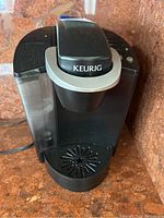 Front view of black Keurig coffee maker showing dispenser and drip tray.