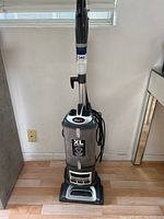 Front view of Shark upright vacuum cleaner showing XL capacity dust cup, handle, and power cord.