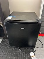 Front view of black Sunbeam mini refrigerator showing door and Sunbeam logo