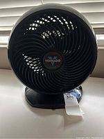 Front view of the black Vornado air circulator fan showing circular grille and logo in center.