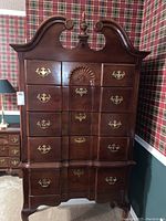 Full front view of entire highboy dresser showing overall silhouette, finish and hardware.