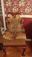Full front view of fox fur vest on a chair showing dense natural fox fur and overall condition