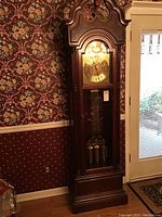 Full view of tall wooden clock case in room setting