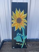 Front view of the hand painted sunflower on the dark canvas background.