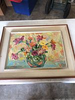 Frontal image of the painting showing colorful floral vase with thick textured brush strokes in a beige double frame with red-brown trim.