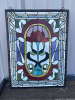 Front view of the stained glass window panel showing the full floral design and colored glass pieces.