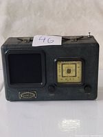 Front view of vintage Daklin radio showing dial, speaker, and badge