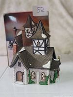 Photo of the Dickens Village church figurine displayed in front of its original box, showing details of the roof, tower, and snow accents.
