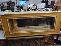 Front view of oak veneer cabinet with glass panel and record selector slots