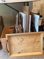 Photo showing wooden tray, blank canvases, wooden hangers, and craft boards stacked together