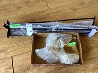 Two sets of table legs shown together: one set of 4 long black hairpin legs, wrapped in bubble wrap and taped, measures 28.5 inches high, and a red box containing 4 short brass-colored legs wrapped in bubble wrap.