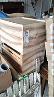 Three stacked wooden crates in a garage space, showing natural wood grain and slatted sides.