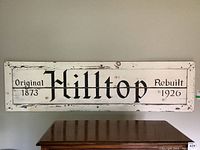 Full front view of the large wooden sign hung on a wall, clearly showing text and distressed paint.