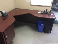Full view of L-shaped corner desk showing overall shape, laminate cherry finish, and drawer cabinet
