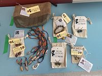 Lot laid out showing all jewelry pieces, cloth pouches with Haitian Creations tags, and a woven toiletry bag