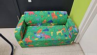 Child's foam sofa with bright green animal print upholstery, shown from front angle
