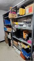 Photo of full metal shelving unit loaded with storage boxes and office supplies.