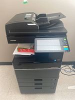 Front view of Toshiba e-Studio 4505AC photocopier with blank paper on output tray