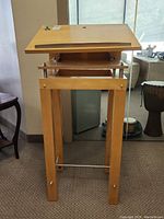 Front view of pulpit stand showing pine frame and metal trim.