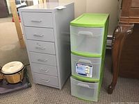 Photo showing metal 6 drawer storage unit next to Sterilite 3 drawer green and clear plastic storage tower.