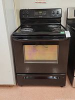 Front view of black Frigidaire electric stove showing oven door with window and control panel.