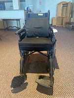 Front view of the Invacare 9000 XT wheelchair showing padded seat and footrests.
