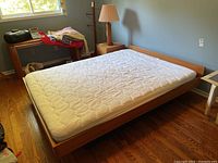 Full queen bed frame with foam mattress in bedroom