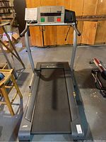 Front view of NordicTrack C2200 treadmill showing running belt and frame with measurement tags on side.