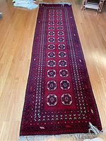Full view of the long wool runner rug on wooden floor, showing overall pattern and colors
