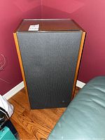 Full view of one Philips speaker showing wooden cabinet and black fabric grille