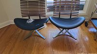Two chairs side by side showing black faux leather seats, metal X-shaped bases, and wooden slatted backs