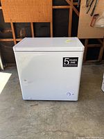 Full view of white Danby chest freezer with 5-year warranty sticker on front.