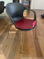 Single Fritz Hansen Tibia chair front view showing shell, armrests, legs and cushion