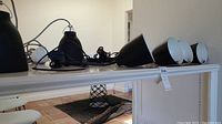 All six black pendant lamps displayed on table with cords and hardware visible