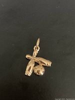 Front view of the bowling ball and pins pendant showing its shape and gold-tone finish.