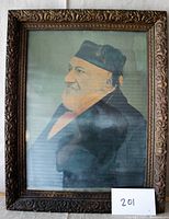 Full view of framed lithograph showing Sir Moses Montefiore in profile wearing a dark coat and headwear, enclosed in a large carved wooden frame