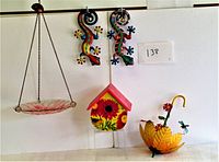 Photo showing full lot including glass bird bath tray hanging by chain, colorful painted bird house, two painted metal geckos, and yellow painted umbrella garden decor with flower and dragonfly