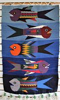 Full view of wall hanging showing all five colorful fish designs on blue background with tassels at bottom.