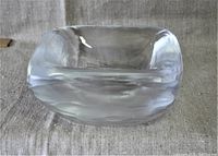 Side view of the clear translucent glass bowl with a textured ice-like finish and square rounded shape
