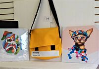Photo of the Pantone mustard yellow messenger bag flanked by the colorful bulldog and cat wall art pieces showing the full lot